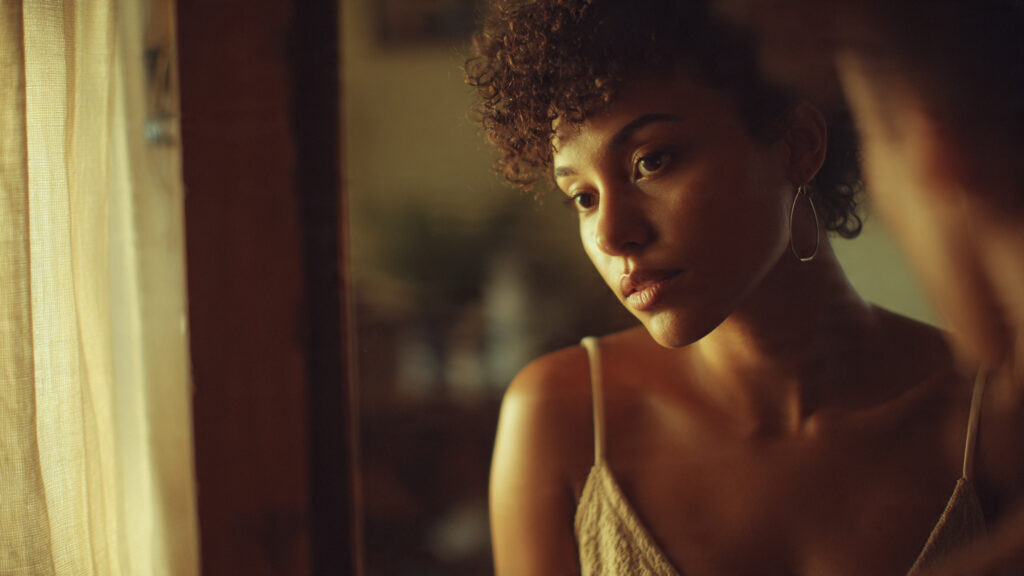 Self-love and healthy relationships concept showing a young adult looking into a mirror while their reflection appears more confident, symbolizing self-growth and emotional healing.