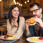 happy couple laughing naturally on a dinner date, demonstrating how to start dating again after a long break with confidence and joy.