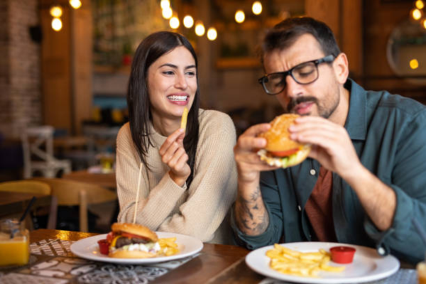 happy couple laughing naturally on a dinner date, demonstrating how to start dating again after a long break with confidence and joy.