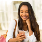 A young woman smiling warmly while checking her smartphone to decide what to do after the first date.